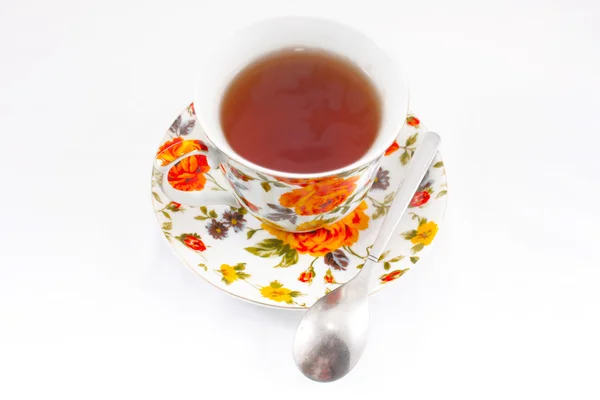 Taza de té clásica con flores rojas y naranjas — Foto de Stock