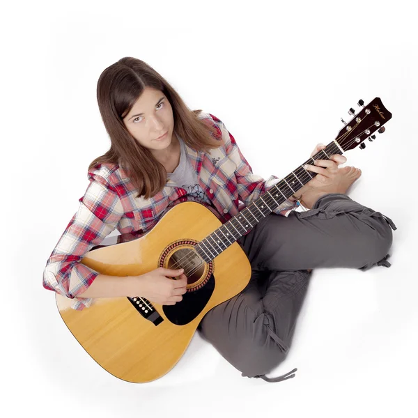 Girl with a guitar sitting on a white floor — Stock Photo, Image