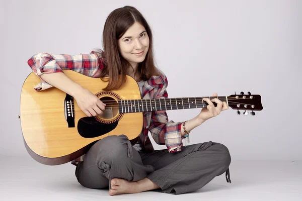 Girl with a guitar sitting — Stock Photo, Image