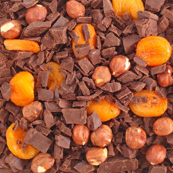 Chocolate com nozes e damascos fundo — Fotografia de Stock