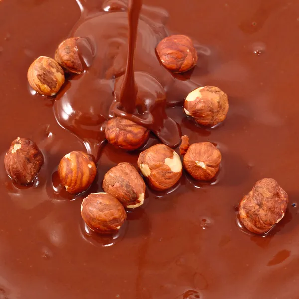 El chocolate fluye sobre las nueces. Aspecto sabroso - fondo de la comida abstracta — Foto de Stock