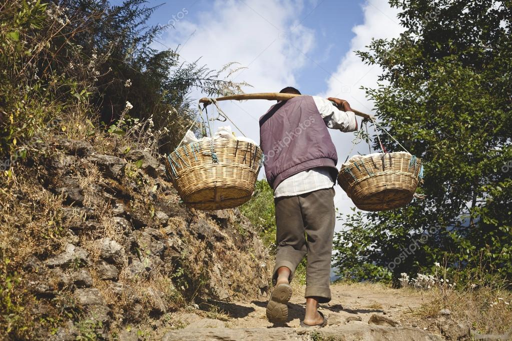 ANNAPURNA NATIONAL PARK, NEPAL - NOVEMBRO 12: O homem nepalês carrega carga pesada no Himalaia em 12 de novembro de 2012 no parque nacional de Annapurna, Nepal fotos, imagens de © Alexandra Lande #26290257