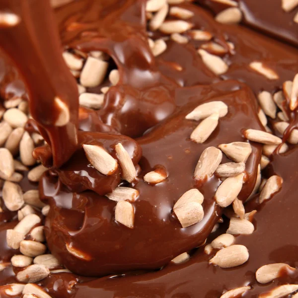 Verter chocolate caliente derretido con semillas de girasol — Foto de Stock