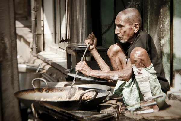 Man cooks meal for sale in street restaurant — Stock Photo, Image