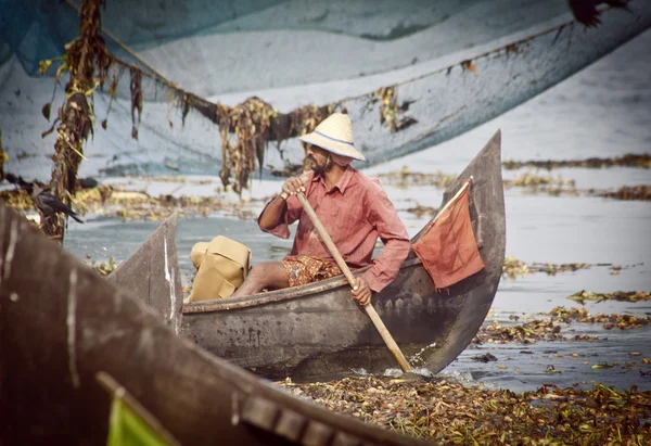 Fisherman fishing in wooden boat — Stock Photo, Image