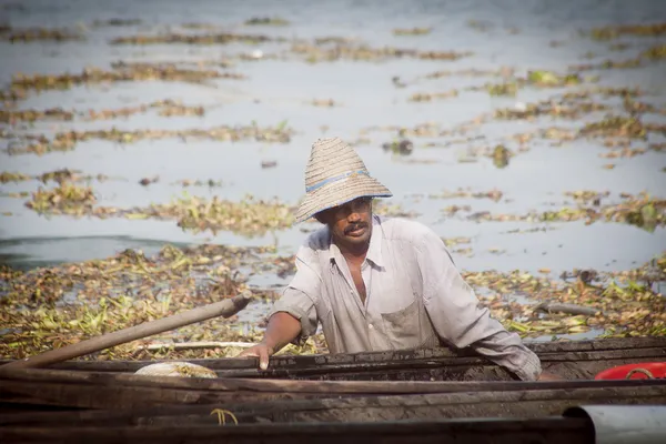 Fisherman fishing in wooden boat — Stock Photo, Image