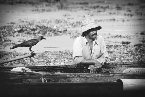 Рыбак рыбачит на деревянной лодке — стоковое фото