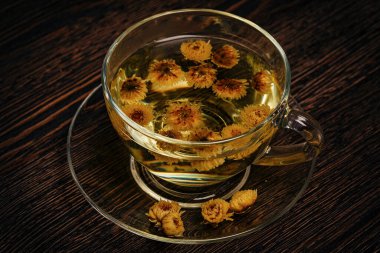 Kasımpatılar ahşap arka planda cam bardakta içerler.