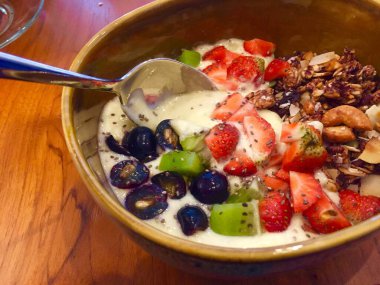 Taze sağlıklı yiyecekler. Meyve ve fındıklı meyve suyu kasesi.