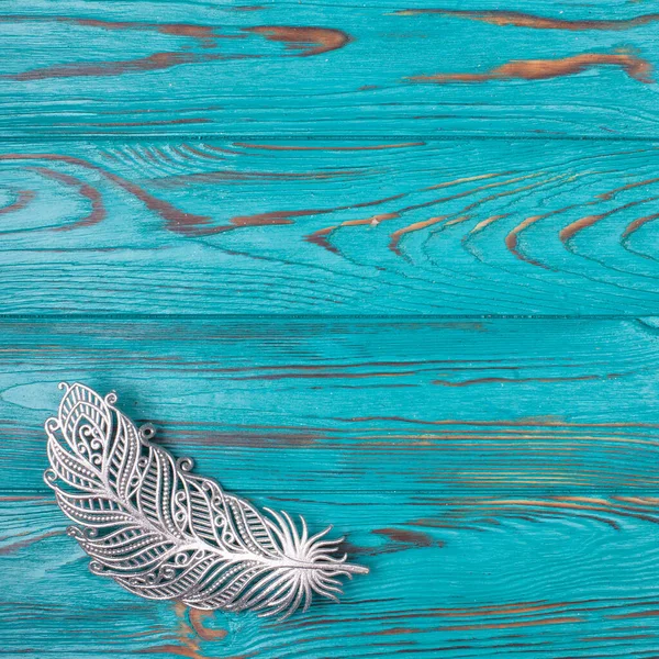 トルコ石の木製の背景に銀装飾羽 — ストック写真