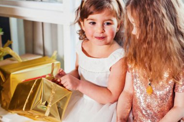 Noel ağacının yanında iki küçük kız arkadaş var.