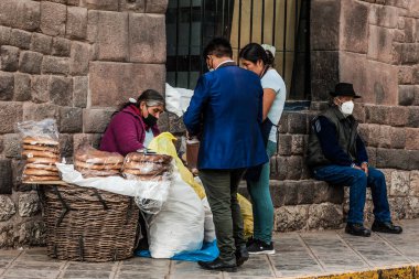Peru - 15 Mayıs 2022: Cuzco 'da geleneksel giyinmiş Perulu insanlar. Cusco, Peru 'da geleneksel ekmek satan kadın, 15 Mayıs 2022