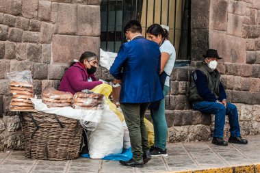 Peru - 15 Mayıs 2022: Cuzco 'da geleneksel giyinmiş Perulu insanlar. Cusco, Peru 'da geleneksel ekmek satan kadın, 15 Mayıs 2022