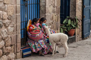 Peru - 15 Mayıs 2022: Cuzco 'da geleneksel giyinmiş Perulu insanlar. 15 Mayıs 2022 'de Cusco, Peru' da, Lama 'nın yanındaki kadın.