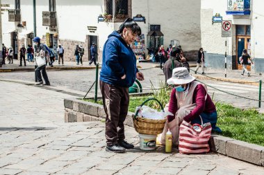 Peru - 15 Mayıs 2022: Cuzco 'da geleneksel giyinmiş Perulu insanlar. 15 Mayıs 2022 'de Peru, Cusco' da geleneksel yemek satan kadın Tamalr.
