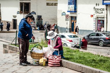 Peru - 15 Mayıs 2022: Cuzco 'da geleneksel giyinmiş Perulu insanlar. 15 Mayıs 2022 'de Peru, Cusco' da geleneksel yemek satan kadın Tamalr.