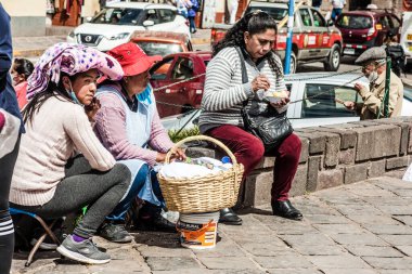 Peru - 15 Mayıs 2022: Cuzco 'da geleneksel giyinmiş Perulu insanlar. 15 Mayıs 2022 'de Peru, Cusco' da geleneksel yemek satan kadın Tamalr.