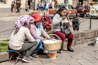 Peru - 15 Mayıs 2022: Cuzco 'da geleneksel giyinmiş Perulu insanlar. 15 Mayıs 2022 'de Peru, Cusco' da geleneksel yemek satan kadın Tamalr.