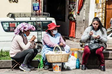 Peru - 15 Mayıs 2022: Cuzco 'da geleneksel giyinmiş Perulu insanlar. 15 Mayıs 2022 'de Peru, Cusco' da geleneksel yemek satan kadın Tamalr.