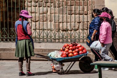 Peru - 15 Mayıs 2022: Cuzco 'da geleneksel giyinmiş Perulu insanlar. Sokakta nar satan bir kız. Cusco, Peru, 15 Mayıs 2022