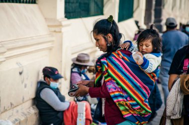 Peru - 15 Mayıs 2022: Cuzco 'da geleneksel giyinmiş Perulu insanlar. Anne ve küçük kızı. Cusco, Peru, 15 Mayıs 2022