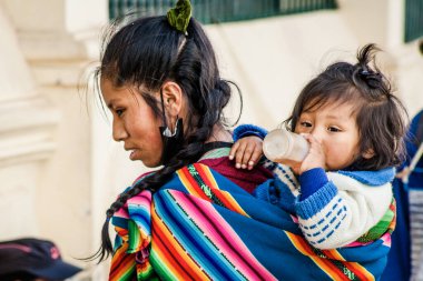 Peru - 15 Mayıs 2022: Cuzco 'da geleneksel giyinmiş Perulu insanlar. Anne ve küçük kızı. Cusco, Peru, 15 Mayıs 2022