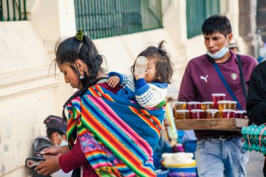 Peru - 15 Mayıs 2022: Cuzco 'da geleneksel giyinmiş Perulu insanlar. Anne ve küçük kızı. Cusco, Peru, 15 Mayıs 2022