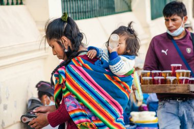 Peru - 15 Mayıs 2022: Cuzco 'da geleneksel giyinmiş Perulu insanlar. Anne ve küçük kızı. Cusco, Peru, 15 Mayıs 2022