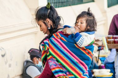 Peru - 15 Mayıs 2022: Cuzco 'da geleneksel giyinmiş Perulu insanlar. Anne ve küçük kızı. Cusco, Peru, 15 Mayıs 2022