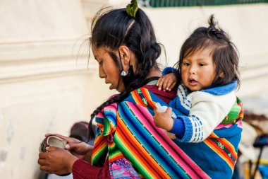 Peru - 15 Mayıs 2022: Cuzco 'da geleneksel giyinmiş Perulu insanlar. Anne ve küçük kızı. Cusco, Peru, 15 Mayıs 2022