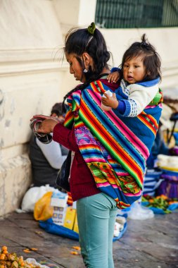 Peru - 15 Mayıs 2022: Cuzco 'da geleneksel giyinmiş Perulu insanlar. Anne ve küçük kızı. Cusco, Peru, 15 Mayıs 2022
