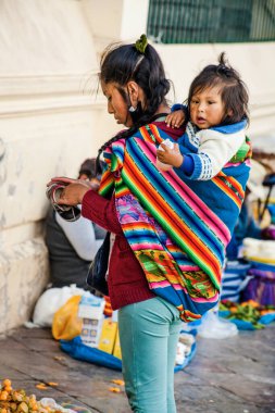 PERU - MAY 15, 2022: Peruvian people in traditional clothes in Cuzco. Mother with her small daughter.  Cusco, Peru, May 15, 2022 clipart