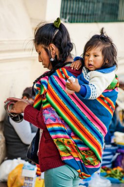 Peru - 15 Mayıs 2022: Cuzco 'da geleneksel giyinmiş Perulu insanlar. Anne ve küçük kızı. Cusco, Peru, 15 Mayıs 2022