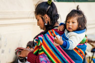 Peru - 15 Mayıs 2022: Cuzco 'da geleneksel giyinmiş Perulu insanlar. Anne ve küçük kızı. Cusco, Peru, 15 Mayıs 2022