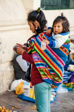 Peru - 15 Mayıs 2022: Cuzco 'da geleneksel giyinmiş Perulu insanlar. Anne ve küçük kızı. Cusco, Peru, 15 Mayıs 2022