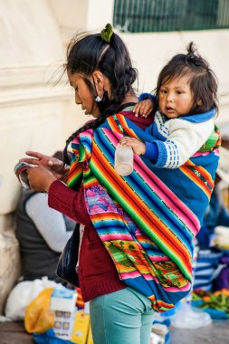 Peru - 15 Mayıs 2022: Cuzco 'da geleneksel giyinmiş Perulu insanlar. Anne ve küçük kızı. Cusco, Peru, 15 Mayıs 2022