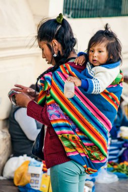 Peru - 15 Mayıs 2022: Cuzco 'da geleneksel giyinmiş Perulu insanlar. Anne ve küçük kızı. Cusco, Peru, 15 Mayıs 2022