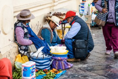 Peru - 15 Mayıs 2022: Cuzco 'da geleneksel giyinmiş Perulu insanlar. Cusco, Peru 'da 15 Mayıs 2022' de sokakta satış yapan bir adam var.