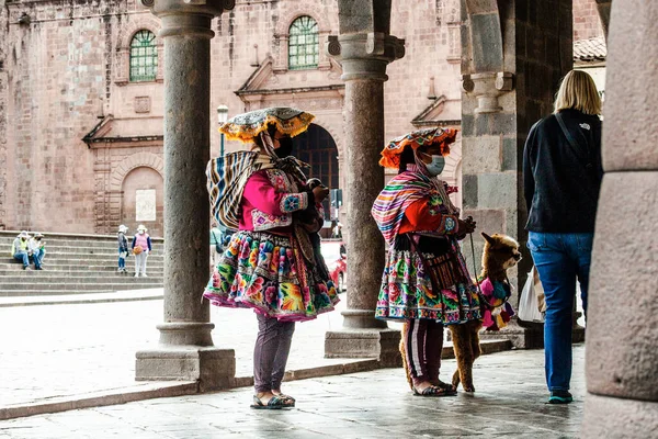 Peru - 15 Mayıs 2022: Cuzco 'da geleneksel giyinmiş Perulu insanlar. 15 Mayıs 2022 'de Cusco, Peru' da, Lama 'nın yanındaki kadın.