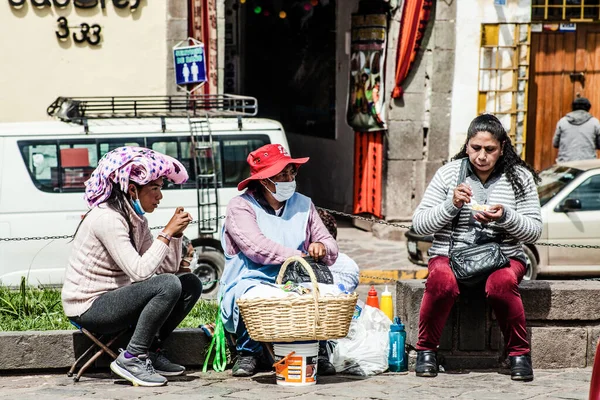 Peru - 15 Mayıs 2022: Cuzco 'da geleneksel giyinmiş Perulu insanlar. 15 Mayıs 2022 'de Peru, Cusco' da geleneksel yemek satan kadın Tamalr.