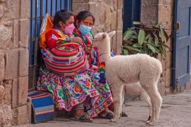 Peru - 15 Mayıs 2022: Cuzco 'da geleneksel giyinmiş Perulu insanlar. 15 Mayıs 2022 'de Cusco, Peru' da, Lama 'nın yanındaki kadın.