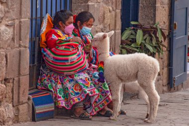 Peru - 15 Mayıs 2022: Cuzco 'da geleneksel giyinmiş Perulu insanlar. 15 Mayıs 2022 'de Cusco, Peru' da, Lama 'nın yanındaki kadın.
