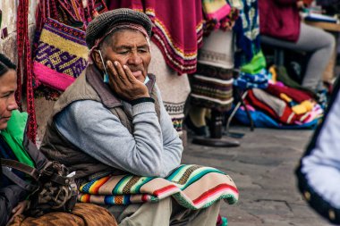 Peru - 15 Mayıs 2022: Cuzco 'da geleneksel giyinmiş Perulu insanlar. Cusco, Peru 'da 15 Mayıs 2022' de sokakta satış yapan bir adam var.