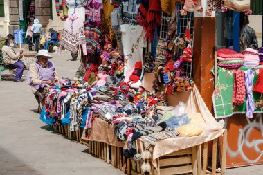 Peru - 15 Mayıs 2022: Cuzco 'da geleneksel giyinmiş Perulu insanlar. Hediyelik eşya satan bir kadın. Cusco, Peru, 15 Mayıs 2022