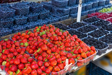 Fresh summer blueberries and strawberries on summer market