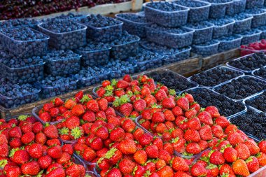 Fresh summer blueberries and strawberries on summer market