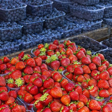 Fresh summer blueberries and strawberries on summer market