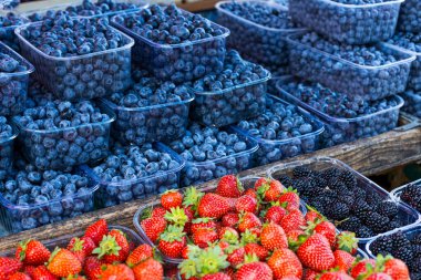 Fresh summer blueberries and strawberries on summer market