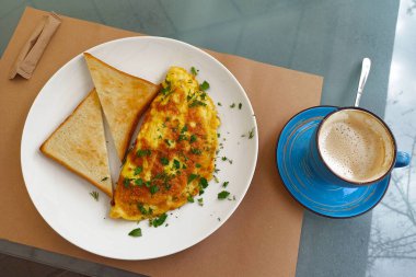 Breakfast served on the table, omelet with toasts and coffee