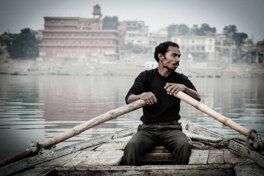 Varanasi, India - November 15, 2013: Man sailing on the boat on Ganges river during Kumbh Mela festival  on November 15, 2013